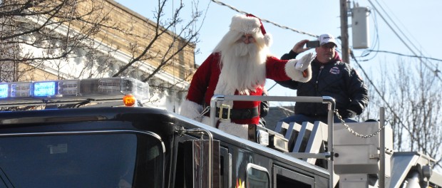 Santa Claus waves to spectators at the parade in Downtown Newton, atop the Tower 804 ladder truck.
