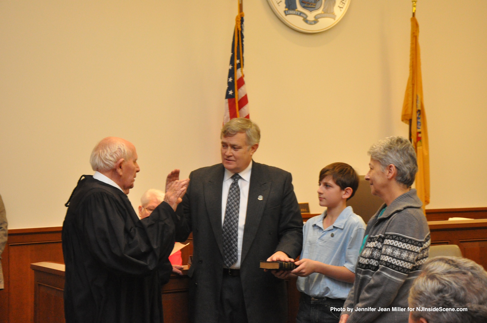 Judge Frederic Weber swears in George Graham, while Graham's wife, Gail, and grandson, Seth, look on.