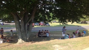 Festival goers relax in the shade with their fare and beverages. Photo by Jennifer Jean Miller.