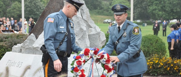 Newton Police Officer Scott King (left) and Hopatcong Police Officer Edward Janosko (right) carry the wreath to the monument. Photo by Jennifer Jean Miller.