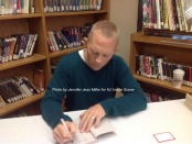 Author Rob Buyea signs a book during the breakfast at Halsted Middle School. Photo by Jennifer Jean Miller.