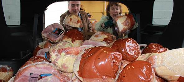 Labor Commissioner Harold J. Wirths and his wife, Debbie, load 125 Christmas hams outside the Weis Supermarket in Franklin, Sussex County, for packaging with other goods and gifts for needy families. Photo courtesy of New Jersey Department of Labor and Workforce Development.