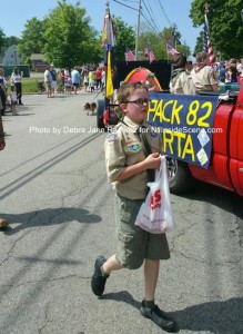 A local scout passes out goodies to parade spectators. Photo by Debra Jane Ramirez.