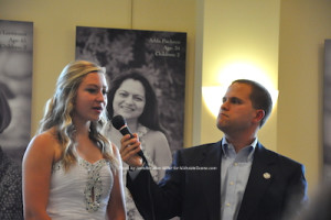 Samantha Brewster stands at the mic with Thomas S. Russo, Jr. Photo by Jennifer Jean Miller.