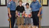 (Left to right) are Lt. Robert E. Osborn, Jr., Stefano Montalvo, Sebastian Montalvo and Chief Mike Richards in the lobby of the Newton Police station. Image courtesy of the Newton Police Department.