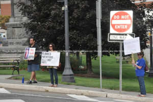 Rally attendees face cars on Main Street with their signs. Photo by Jennifer Jean Miller. 