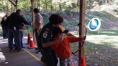 Stephen R. helping a scout properly hold a bow. Image courtesy of Venture Crew 276.