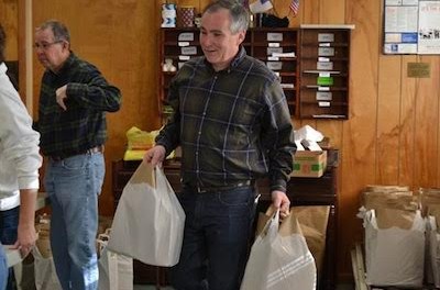 Commissioner Harold J. Wirths of the New Jersey Department of Labor and Workforce Development helps volunteers at the Sussex United Methodist Church organize and bag complete Thanksgiving dinners to be distributed to needy families throughout Sussex County. Image provided.