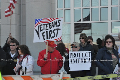 Those on the counter demonstration side hold up signs asking that veterans be placed first. Photo by Jennifer Jean Miller.