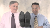 Stanley Praimnath and Brian Clark, who became friends after Clark rescued Praimnath on 9/11/01, marvel at the condition of Praimnath's shoes from the events that day. Image courtesy of Guideposts/YouTube.